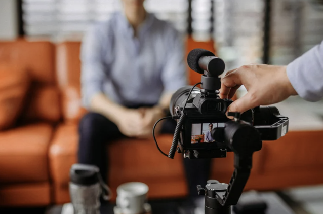 Image of a camera filming a person