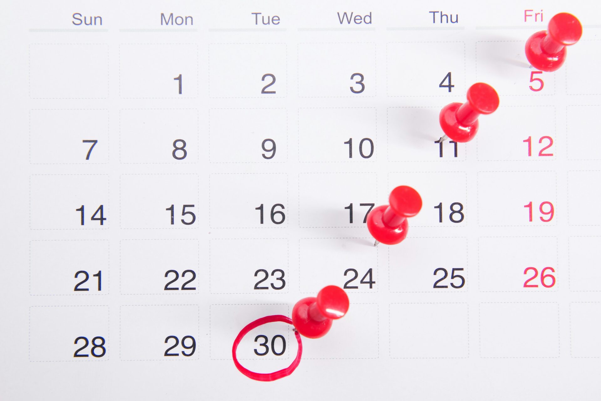 Calendar with pushpins marking days.